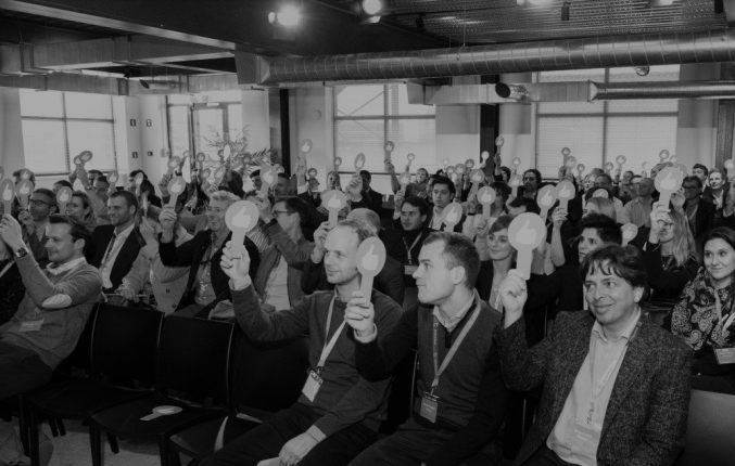 Shot of conference attendees holding up thumbs-up signs