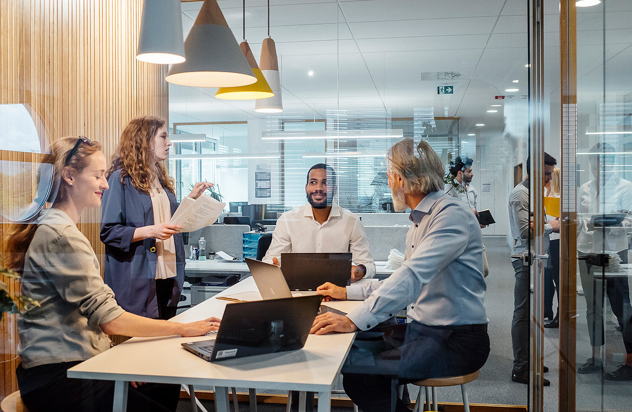 People talking in a modern office, perhaps about E2E planning transformation