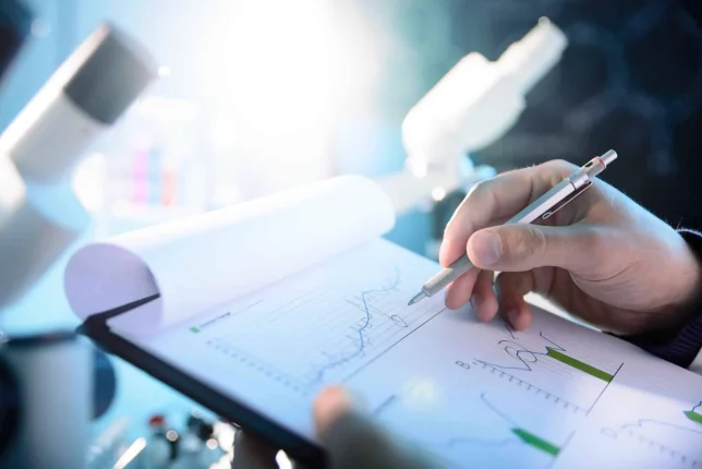 Employee assesses a chart on a clipboard, illustrating the topic of this video: reaching laboratory targets with actionable KPIs