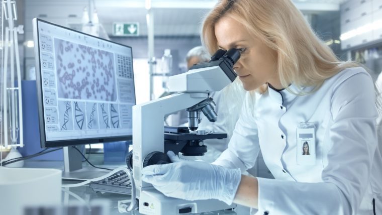 A lab analyst investigates complex data via a digital microscope. This illustrates one aspect of this webinar's focus: the challenges of standardizing CGT digital operations and IT systems