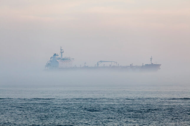 A cargo ship traveling through fog.