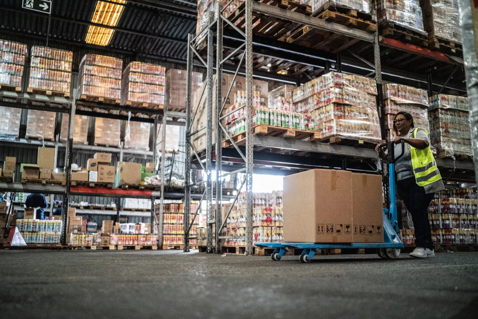 Warehouse worker using a hand truck carrying boxes