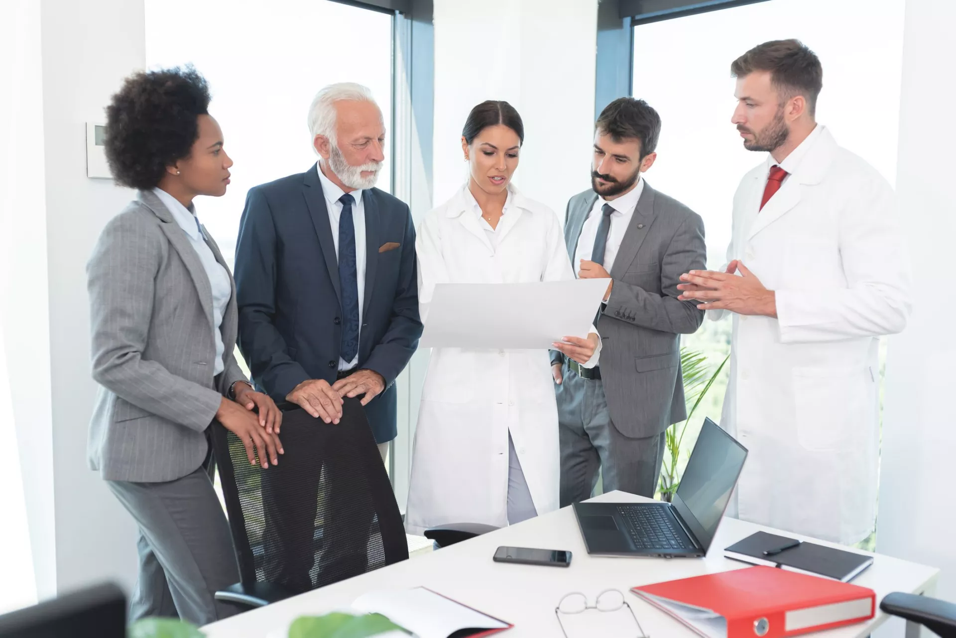 Business people with medical workers analyzing document at office