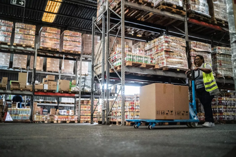 Warehouse worker using a hand truck carrying boxes